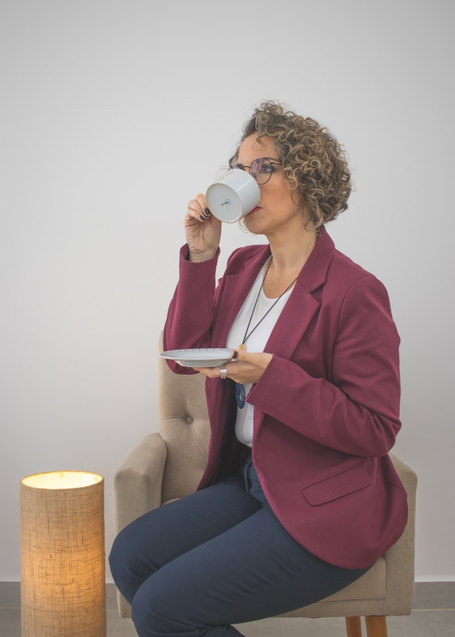 Paula Crescentini tomando café em uma poltrona